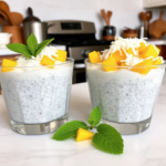 Final presentation of Overnight Chia Pudding with Mango & Coconut, garnished with fresh mint leaves in a cozy kitchen setting